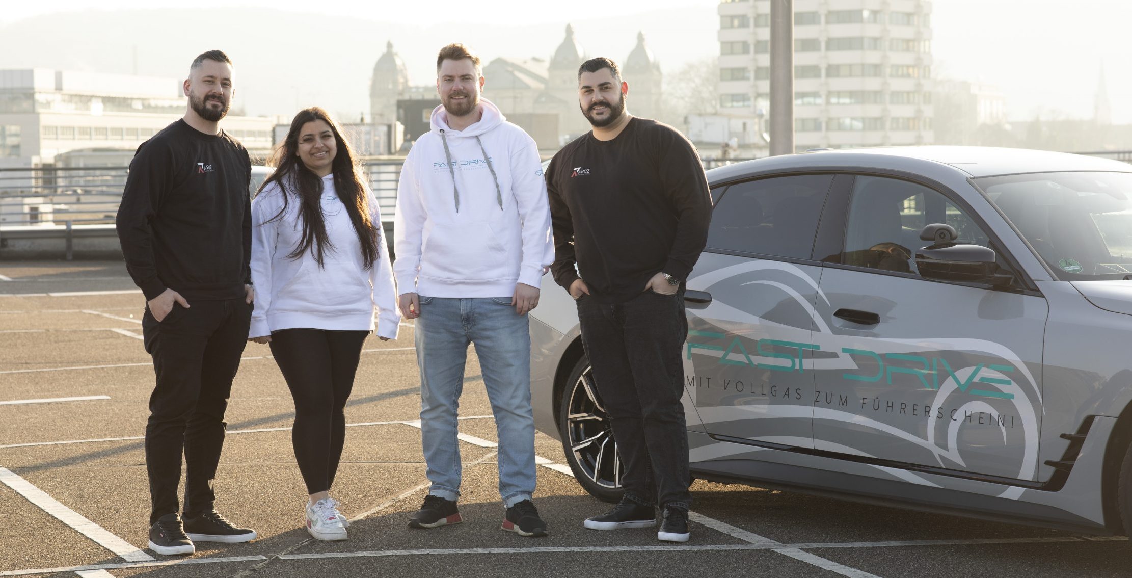 Die 2 Gründer von Aroz in der schwarzen Kleidung und die 2 Gründer von Fast Drive Wuppertal in der weißen Kleidung im Parkhaus.