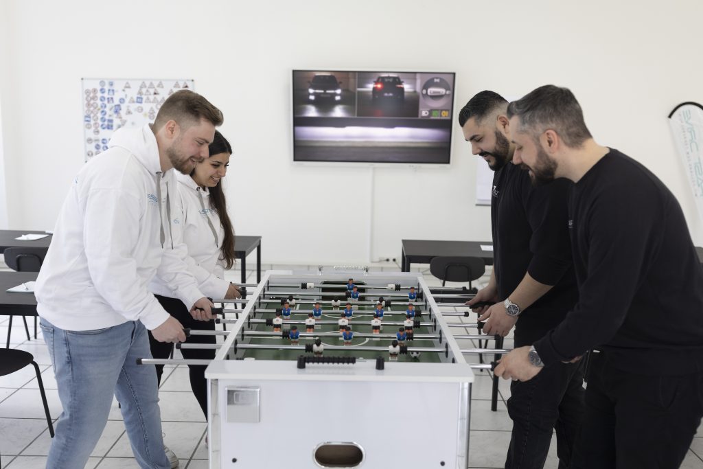 Die Besitzer von Fast Drive Wuppertal und das Team von Aroz Webdesign spielen gemeinsam Tischfußball.